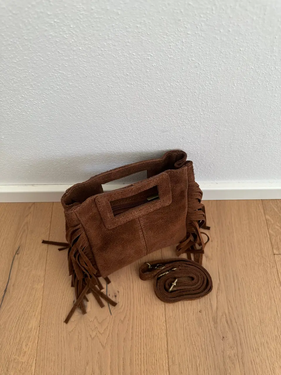 The brown suede mini fringe bag with its leather crossbody strap