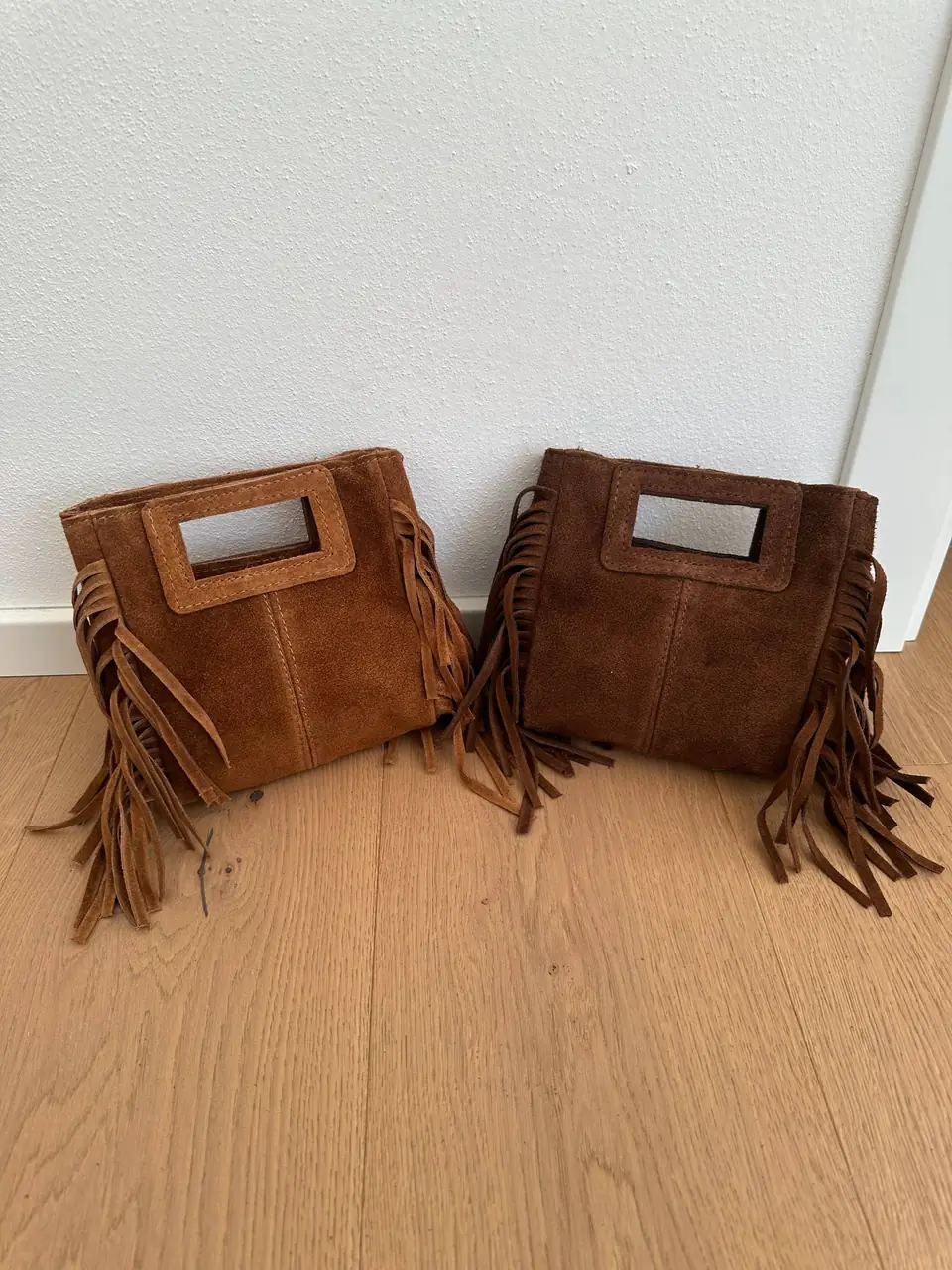 Cognac and brown suede mini fringe bags side by side