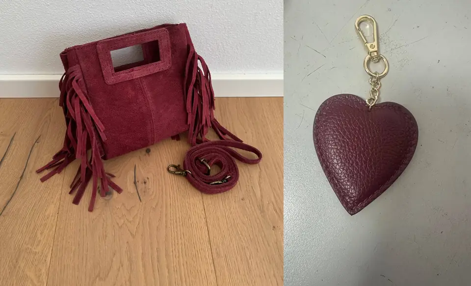 The burgundy suede mini fringe bag next to a burgundy leather heart charm
